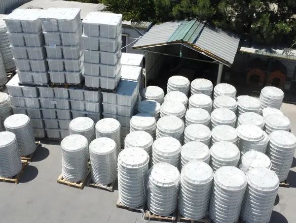 Aerial view of palletised rectangular enclosures next to stacks of circular composite covers.